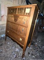Front angled view of the brown four drawer wooden dresser showing drawer design and handles