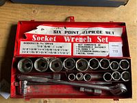 Photo of the 21-piece six point socket wrench set in red metal case with sockets, ratchet, T-bar, and extension bars visible.