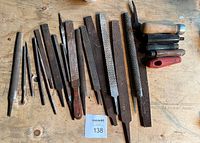 Full lot of 15 assorted rasps, files, and handles laid out on a wooden surface showing condition and variety.