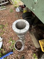 Segment of Selkirk metal chimney pipe standing upright on ground with removable collar on side.