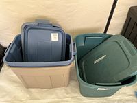 Photo showing beige storage tote with blue lid and teal storage tote with matching lid side by side, both open.