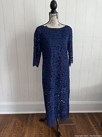 Front view of navy blue lace dress displayed on a mannequin showing floral lace pattern, mid-length 3/4 sleeves, boat neckline and midi length
