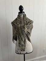 Scarf draped on mannequin front view showing check pattern and fringe detail