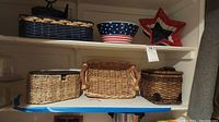 Shelf showing six wicker baskets and one plastic patriotic bowl with star design