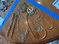 Overview photo showing all bracelets, necklaces, and earrings arranged on a wooden surface.