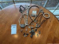 Photo of all jewelry pieces laid out on the table including necklaces, earrings, and bracelet for overview and inventory