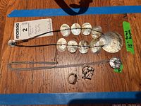 Overview of the lot items showing mother of pearl necklace, sterling silver chain, and two rings on wooden surface.