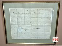 Front view of framed document with gilt-tone wood frame and grey mat