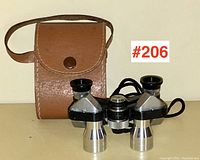 Front view of opera glasses with leather case and lot number