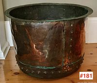 Front view of copper cauldron showing cylindrical form, flared rim and overall patina