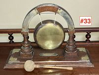 Frontal view of gong on oak base with mallet