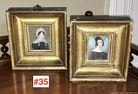 Two framed miniature portraits displayed side by side on wooden surface, labeled #35.