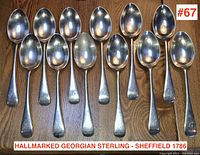 12 spoons arranged in two rows on wood surface, image includes watermark and lot number