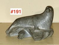 Front angle view showing adult seal and seal pup head on rock