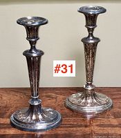 Pair of tall Victorian Sheffield plate candlesticks showing full height and decorative details.