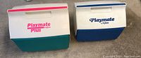 Two vintage Igloo Playmate coolers side by side, one Playmate Plus and one Playmate, showing overall condition and design.