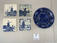 Four blue and white 6x6 inch Delft tiles with windmill and ship scenes plus one blue and white round Staffordshire plate.