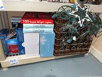 Photo showing holiday light strings with various bulbs on green wiring, including clear and folding star-shaped lights on green string.