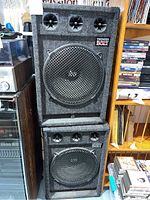 Two Thunder Bolt speakers stacked on each other with black and grey upholstery and visible wear.