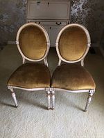 Both chairs front view on carpeted floor with painted cabinet background