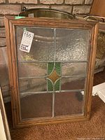 Clear image of the wood framed stained glass window showing texture in glass and central colored design.