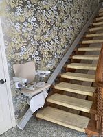 Overall view of straight rail and beige seat installed on staircase