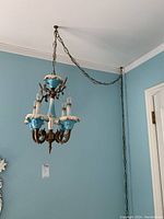 Overall view of chandelier suspended from ceiling by chain