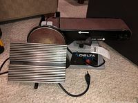 Full view of Delta combination disc and belt sander showing sanding surfaces, adjustable work rest and power cord.