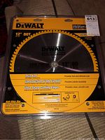 Front view of the DeWalt 12" 80T saw blade in original packaging showing branding and product details.
