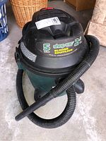 Shop-Vac wet/dry vacuum showing full unit with hose attached and wear visible.