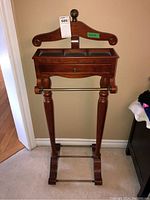 Front view of wooden valet stand with drawer and compartments