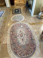 Four area rugs arranged on a tile floor showing variations in shape, color and design