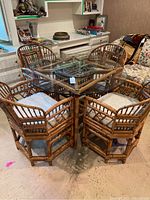 Full overview of the round glass table and four bamboo rattan chairs
