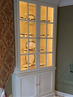Full view of white display cabinet containing upper and lower cabinet items