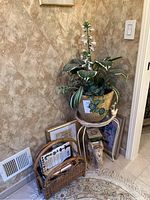 Corner setup showing ceramic planter on side table with wicker basket and framed art on floor.