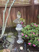 Front view of entire lantern in garden setting showing base, pedestal, lantern chamber and pagoda cap