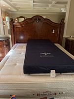 Full frontal view of assembled headboard and footboard set on demonstration mattress