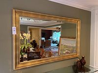 Large rectangular mirror mounted on wall reflecting dining room interior