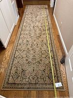 Full-length view of runner on hardwood floor with tape measure showing overall length.