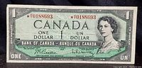 Front of 1954 Canadian one dollar bill showing Queen Elizabeth II portrait and serial number with asterisk.