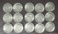Obverse side of 15 circulated 1974 Eisenhower $1 dollar coins showing Eisenhower profile and date with various mint marks.