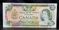 Front of 1979 Canadian $20 bill, showing portrait of Queen Elizabeth II and Canadian coat of arms.