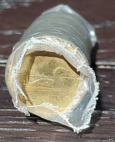 Close-up photo of one side of the coin roll showing the loon design and '1867-1992' marking visible through the protective plastic wrapping.