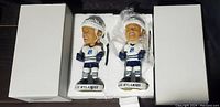 Two Alex Nylander bobble heads in white foam packaging with boxes on each side.