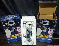 Two Mississauga Steelheads Sauga #74 bobbleheads in original boxes with one out of box partially wrapped in protective plastic.