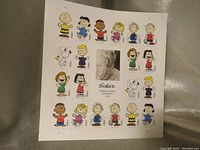Photo of full unused US Postal Service stamp sheet featuring Charles Schulz Peanuts characters and commemorative center portrait of Schulz