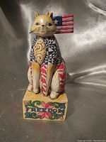 Front view of the Jim Shore Heartwood Creek cat figurine displaying the intricate pattern details, American flag, and 'FREEDOM' text on the base.
