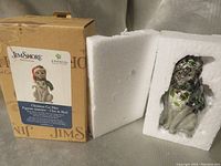 Photo of the Jim Shore Christmas Cat Mini figurine still in protective styrofoam packaging alongside its original Jim Shore branded box.