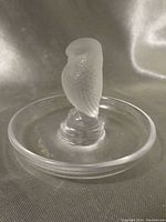 Front side view of clear and frosted crystal owl figurine mounted on round crystal dish