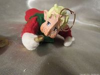 Close-up of the Gabriel angel doll's detailed face with painted features, wire halo, and felt clothing.